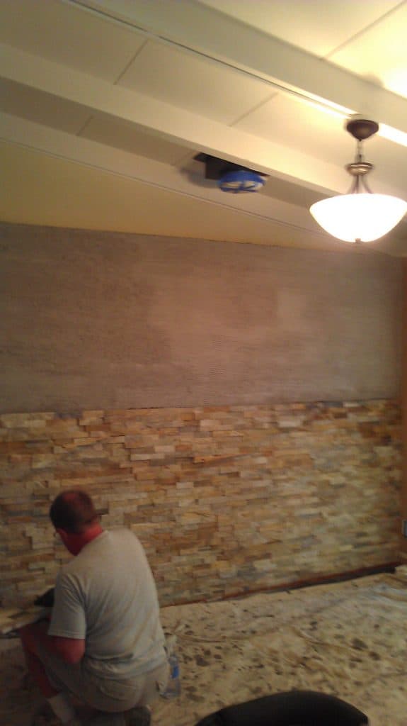 Half of wall finished with new quartz tile.