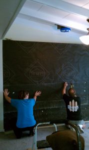 Attaching tar paper to plywood wall for quartz stone installation.