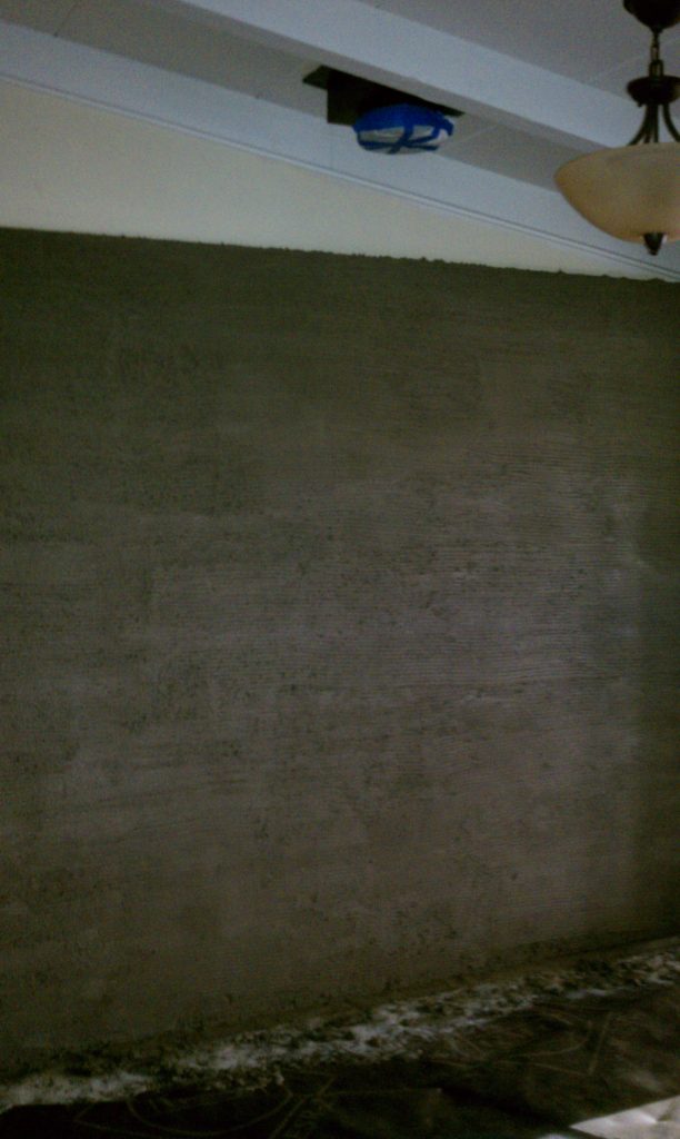 Wall skim coated with mortar to receive quartz tiles.